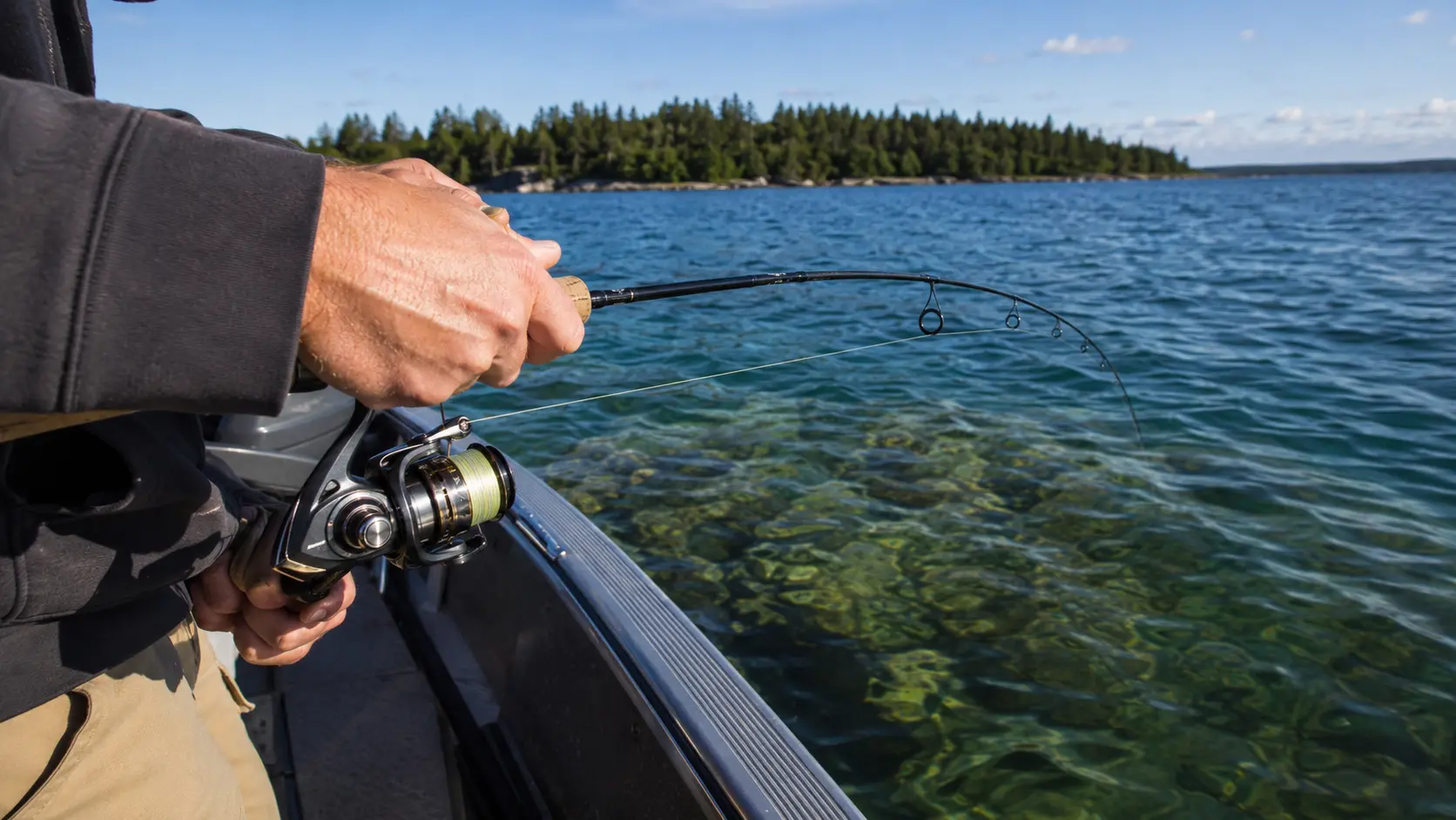 Close view of an angler jigging beside an aluminum fishing boat